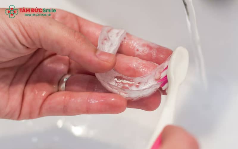 Vệ sinh khay mỗi ngày bằng bàn chải mềm và nước ấm giúp ngăn vi khuẩn, duy trì độ trong suốt
